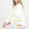 White sweater with yellow, blue and orange stripes down the sleeve