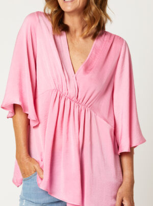 pink silk like top with a v-neck and mid length sleeves and elastic under the bust