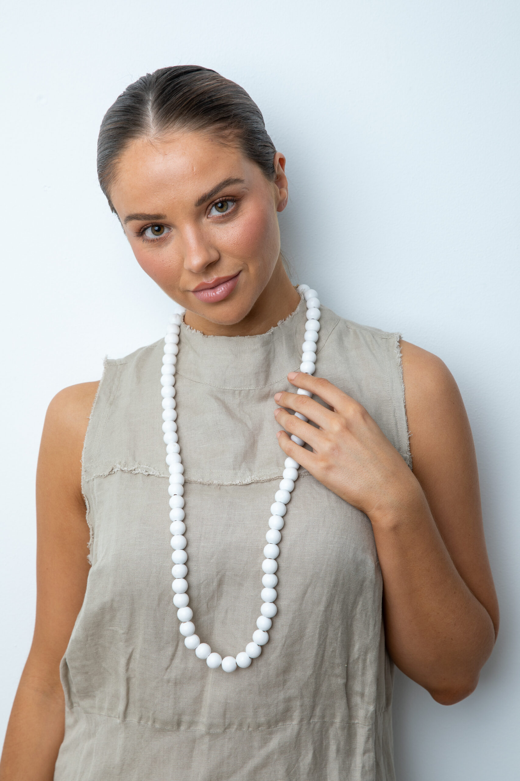 girl wearing a white wooden bead necklace